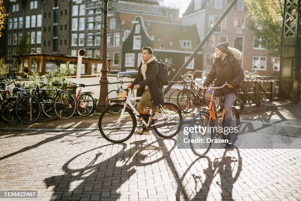 lgbt-paar über städtereisen-diverse millennial-sulschwund sind in beziehung und verbringen zeit mit städtereise - amsterdam bike stock-fotos und bilder