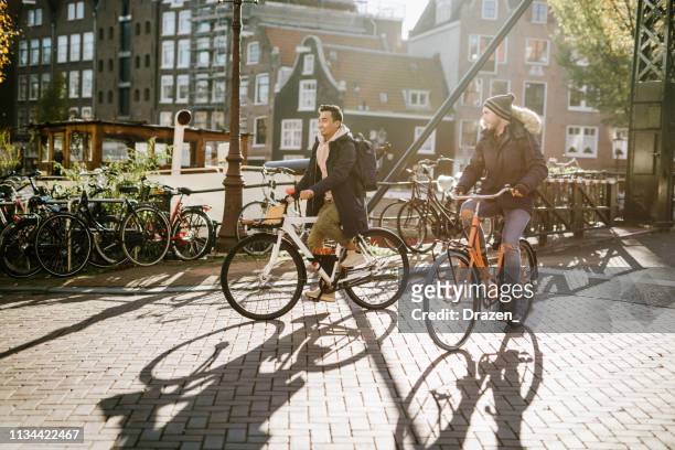 lgbt couple on city break - diverse millennial gay guys are in relationship and spending time on city break - amsterdam stock pictures, royalty-free photos & images