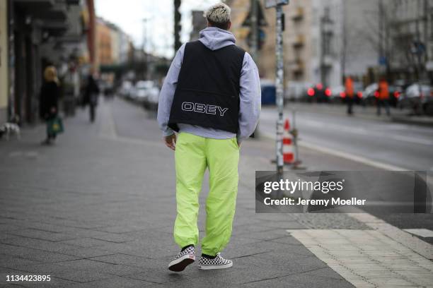 Richy Koll wearing Champion x Supreme pants, Vans shoes and Obey vest on March 07, 2019 in Berlin, Germany.