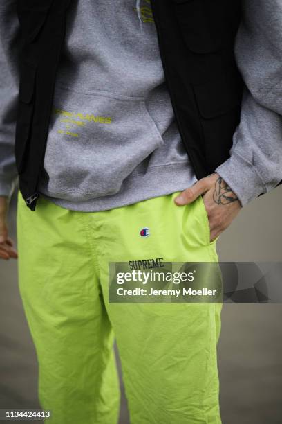 Richy Koll wearing Champion x Supreme pants, Vans shoes and Obey vest on March 07, 2019 in Berlin, Germany.