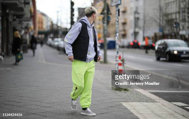 Richy Koll wearing Champion x Supreme pants, Vans shoes and Obey vest on March 07, 2019 in Berlin, Germany.