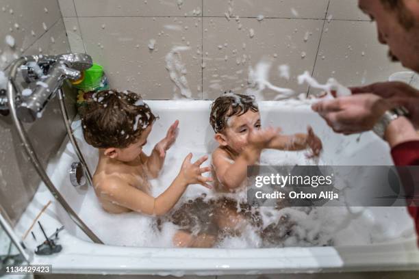 brüder spielen in der badewanne - brothers bathroom stock-fotos und bilder