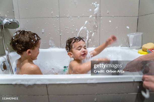 brüder spielen in der badewanne - brothers bathroom stock-fotos und bilder