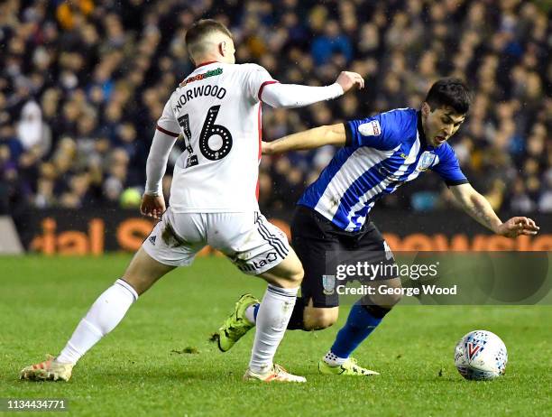 Fernando Forestieri of Sheffield Wednesday is challenged by Oliver Norwood of Sheffield United during the Sky Bet Championship match between...