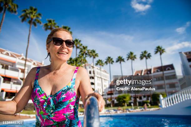 happy senior woman enjoying in the swimming pool - playa de las americas stock pictures, royalty-free photos & images