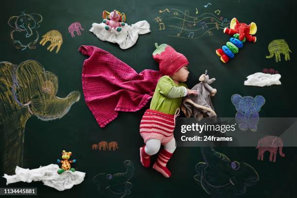 baby girl sleeping against drawings on blackboard, overhead view - sleeping elephant stock pictures, royalty-free photos & images