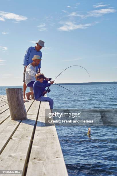 boy with father and grandfather fishing, utvalnas, sweden - summer 2013 stock pictures, royalty-free photos & images