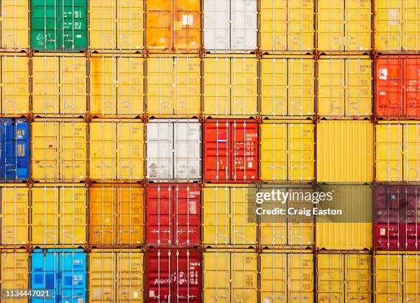 stacks of cargo containers - yellow cargo container stock pictures, royalty-free photos & images
