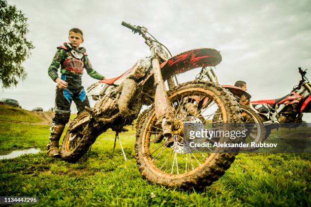 two boys checking motorcycles at motocross - motorcross stock pictures, royalty-free photos & images