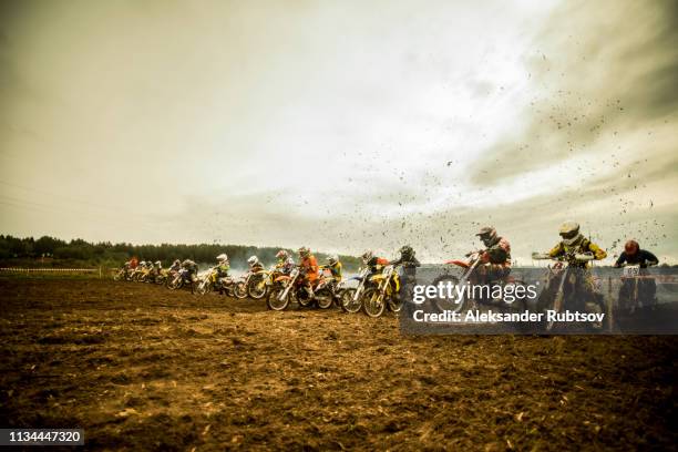 group of boys on motorcycles at motocross start line - motorradsport stock-fotos und bilder