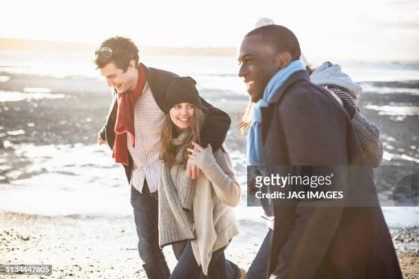 two adult couples out strolling on the beach - romantic couple walking winter beach stock pictures, royalty-free photos & images
