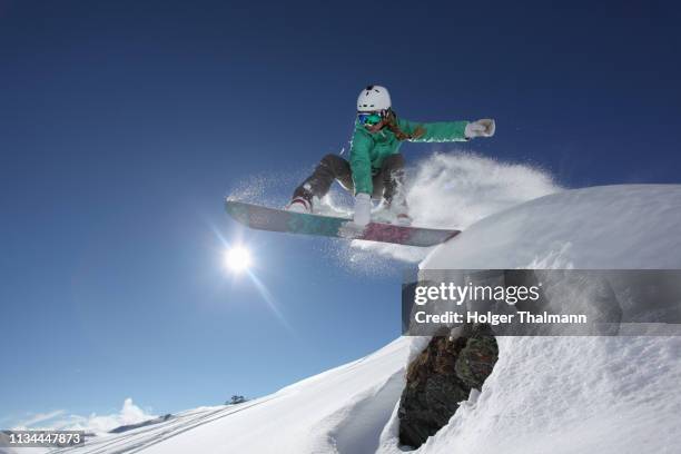 young woman jumping with snowboard, mayrhofen, tyrol, austria - snowboard jump bildbanksfoton och bilder