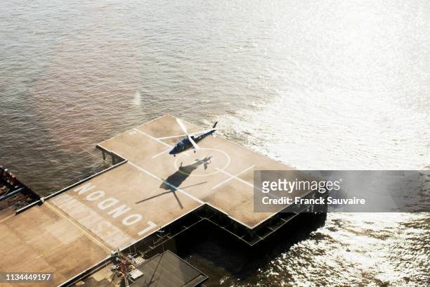 helicopter hovering over riverside helicopter landing pad, london, uk - hubschrauber landeplatz stock-fotos und bilder