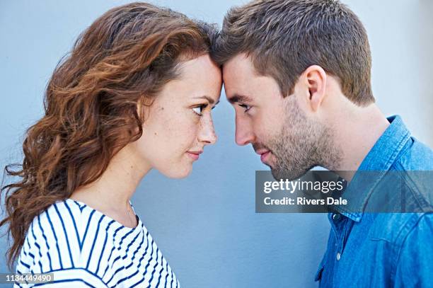 close up of couple forehead to forehead - face à face photos et images de collection
