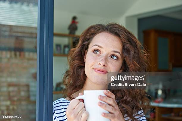 close up of woman with mug - terrassentüre stock-fotos und bilder
