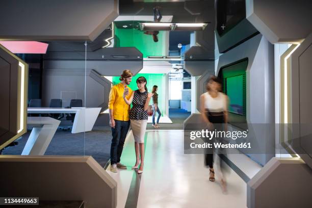 business people discussing on a busy office corridor - calota - fotografias e filmes do acervo