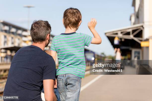 son with father waving to mother on platform - waving goodbye stock pictures, royalty-free photos & images