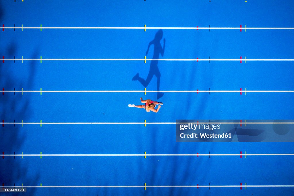 Top view of female runner on tartan track