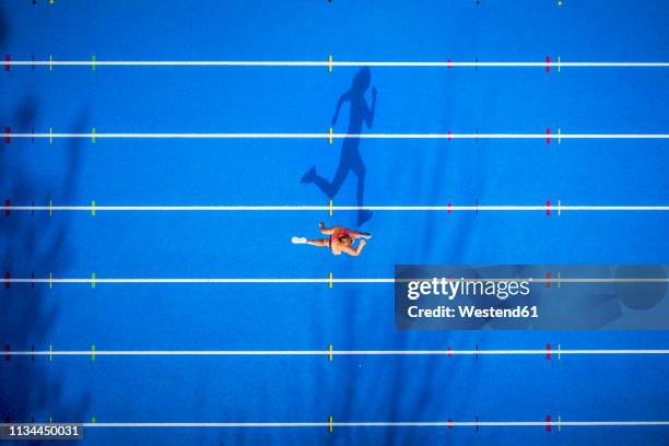 top view of female runner on tartan track - leichtathletikveranstaltung stock-fotos und bilder