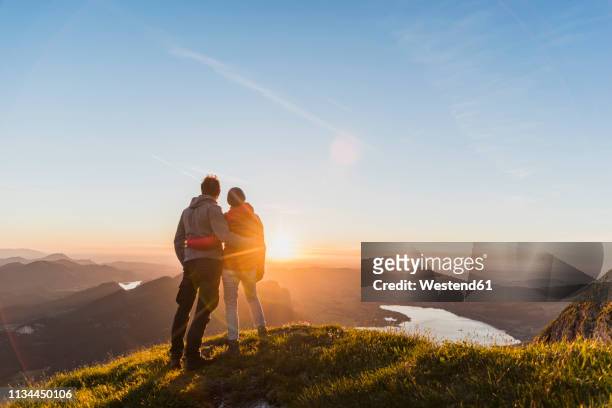 austria, salzkammergut, couple standing on mountain summit, enjoying the view - couple looking at view stock pictures, royalty-free photos & images