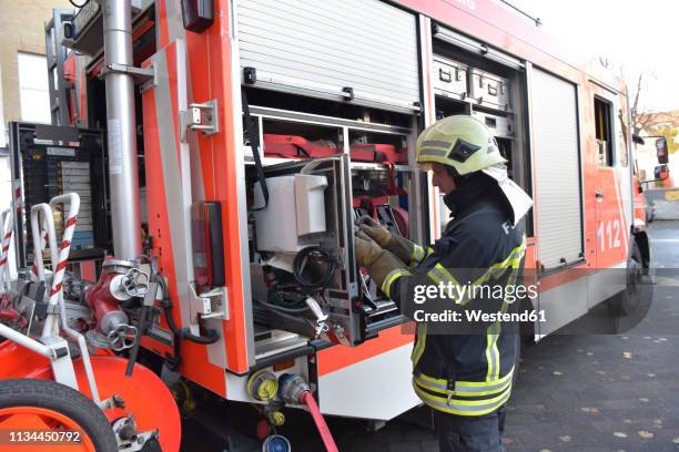 firefighter standing at fire engine - fire engine ストックフォトと画像