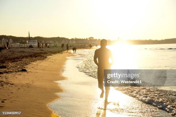 man jogging at the beach at sunset - rostock stock pictures, royalty-free photos & images