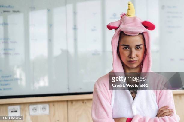 woman wearing unicorn onesie, standing in front of whiteboard, looking stubborn - unleash creativity stock pictures, royalty-free photos & images