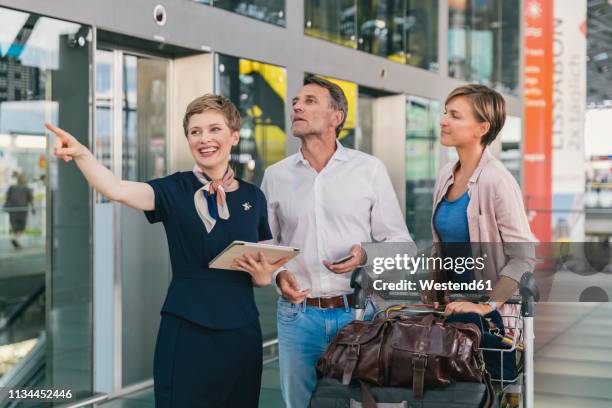 airline employee assisting couple with baggage cart at the airport - tourist asking stock pictures, royalty-free photos & images