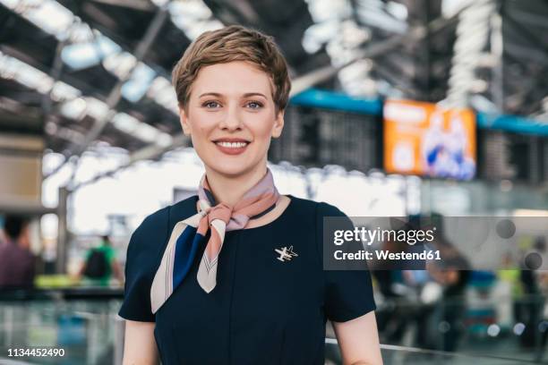 portrait of smiling airline employee at the airport - tripulación fotografías e imágenes de stock