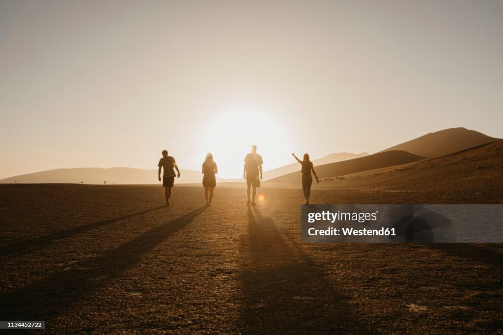 Namibia, Namib desert, Namib-Naukluft National Park, Sossusvlei, friends walking at Dune 45 at sunrise