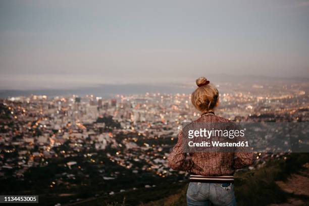 south africa, cape town, kloof nek, woman woman looking at cityscape at sunset - blonde hair woman city stock pictures, royalty-free photos & images