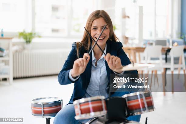 young businesswoman playing percussion - drumstok stockfoto's en -beelden