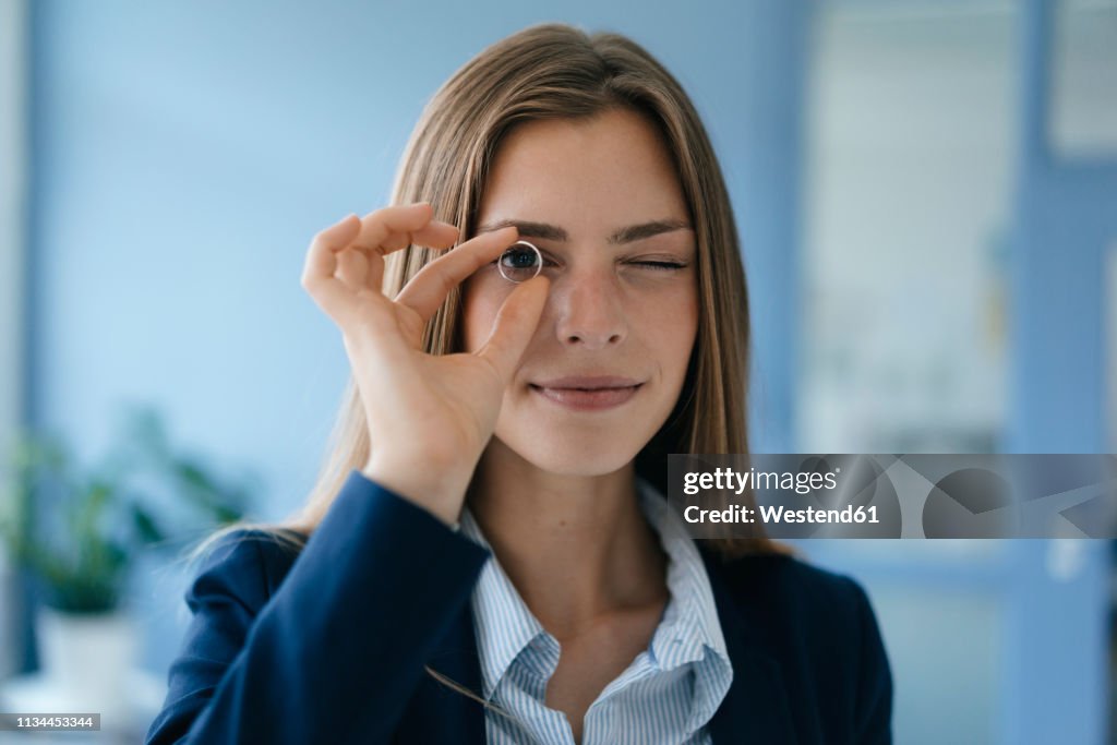 Young businesswoman looking through a wegging ring