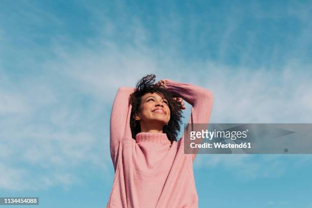 portrait of happy young woman enjoying sunlight - una sola mujer fotografías e imágenes de stock