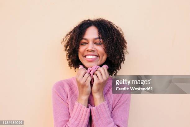 portrait of happy young woman wearing pink pullover - neckline stock pictures, royalty-free photos & images
