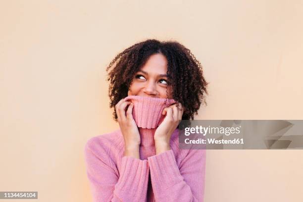 portrait of young woman wearing pink pullover - mock turtleneck fotografías e imágenes de stock