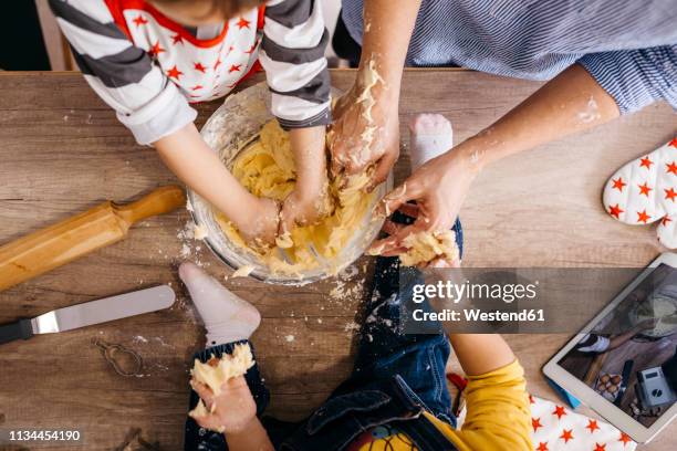 boy preparing dough together with mother and little sister - buttermilk biscuit stock-fotos und bilder