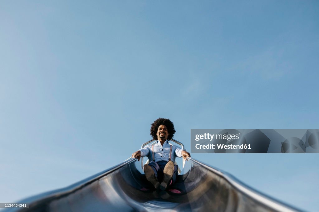 Smiling man sitting on slide