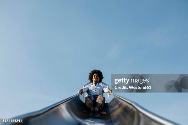 smiling man sitting on slide - sliding stock pictures, royalty-free photos & images