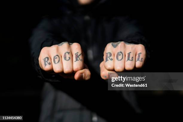 man showing his tattooed hands, close-up - rock'n roll stockfoto's en -beelden