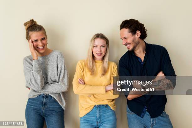 three friends in front of a yellow wall, having fun - three people stock pictures, royalty-free photos & images