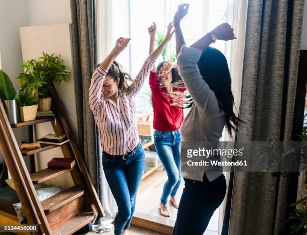 three women at home having a party and dancing - frau tanzt im wohnzimmer stock-fotos und bilder