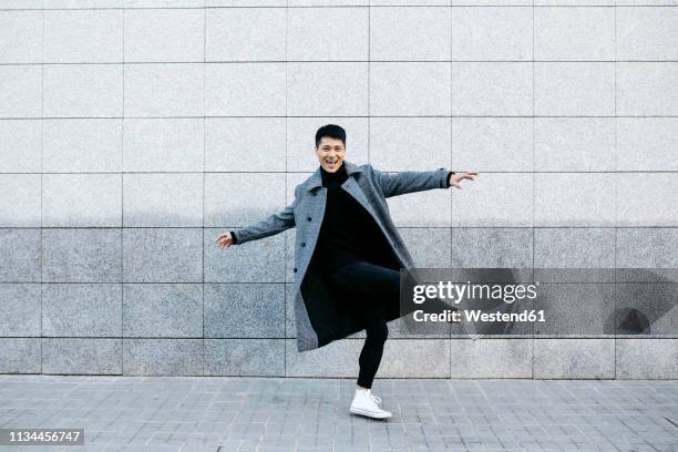 stylish young man dancing on the street - fashionable asian stock pictures, royalty-free photos & images