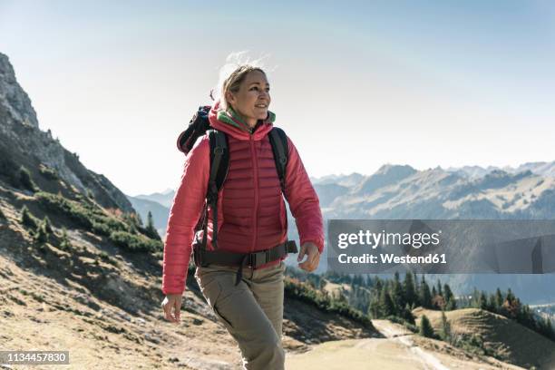 austria, tyrol, smiling woman on a hiking trip in the mountains - pink jacket stock pictures, royalty-free photos & images