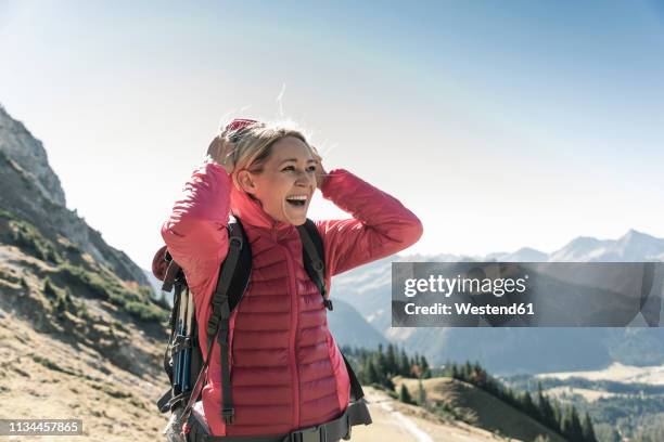austria, tyrol, happy woman on a hiking trip in the mountains enjoying the view - pink coat stock pictures, royalty-free photos & images