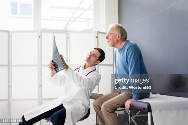 doctor discussing mrt image with patient in medical practice - man talking to doctor bildbanksfoton och bilder