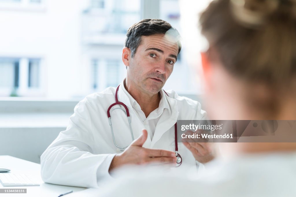 Portrait of doctor talking to patient in medical practice