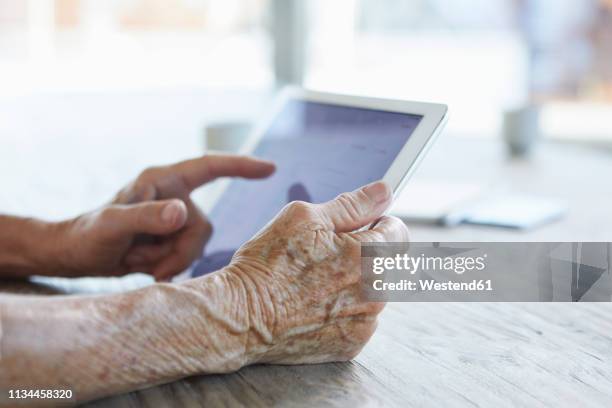 woman's hand holding digital tablet, close-up - old man close up stock-fotos und bilder