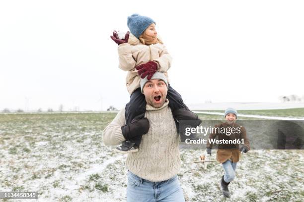 happy father with two children in winter landscape - funny snow stock-fotos und bilder