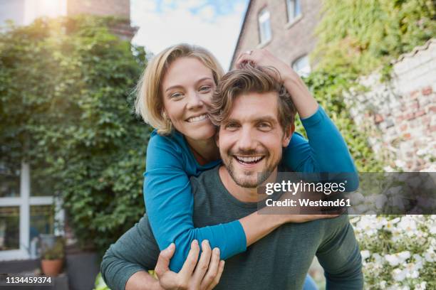 portrait of happy couple in garden of their home - amor proprio photos et images de collection